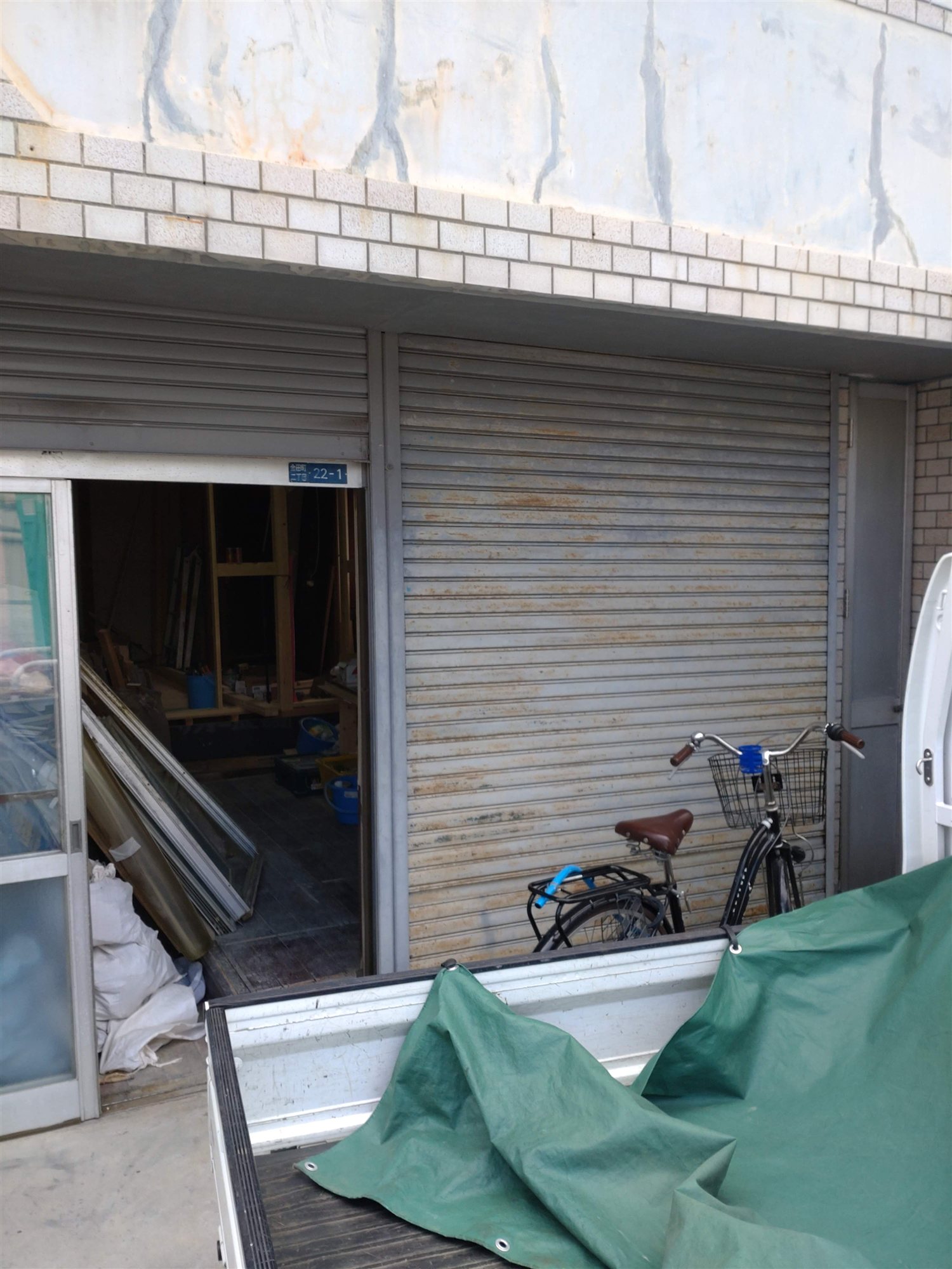 守口市ガレージハウスの改修前の外観。錆びたシャッターと自転車