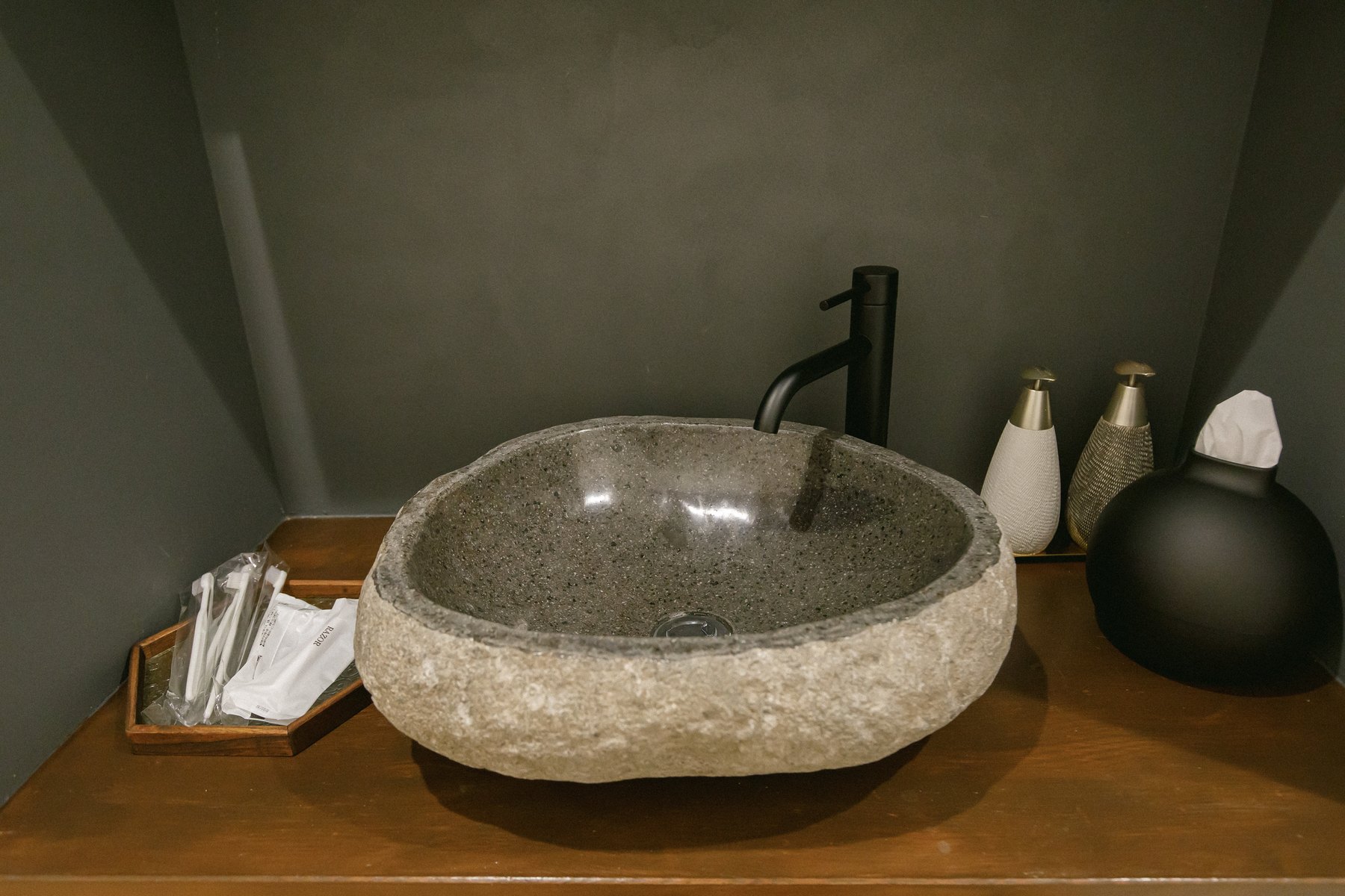 彗 −SUI− の洗面台。石を使ったボウルと黒い水栓